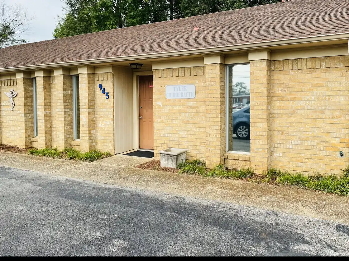 Tyler Chiropractic's single-storey buff brick building with blue 945 house numerals